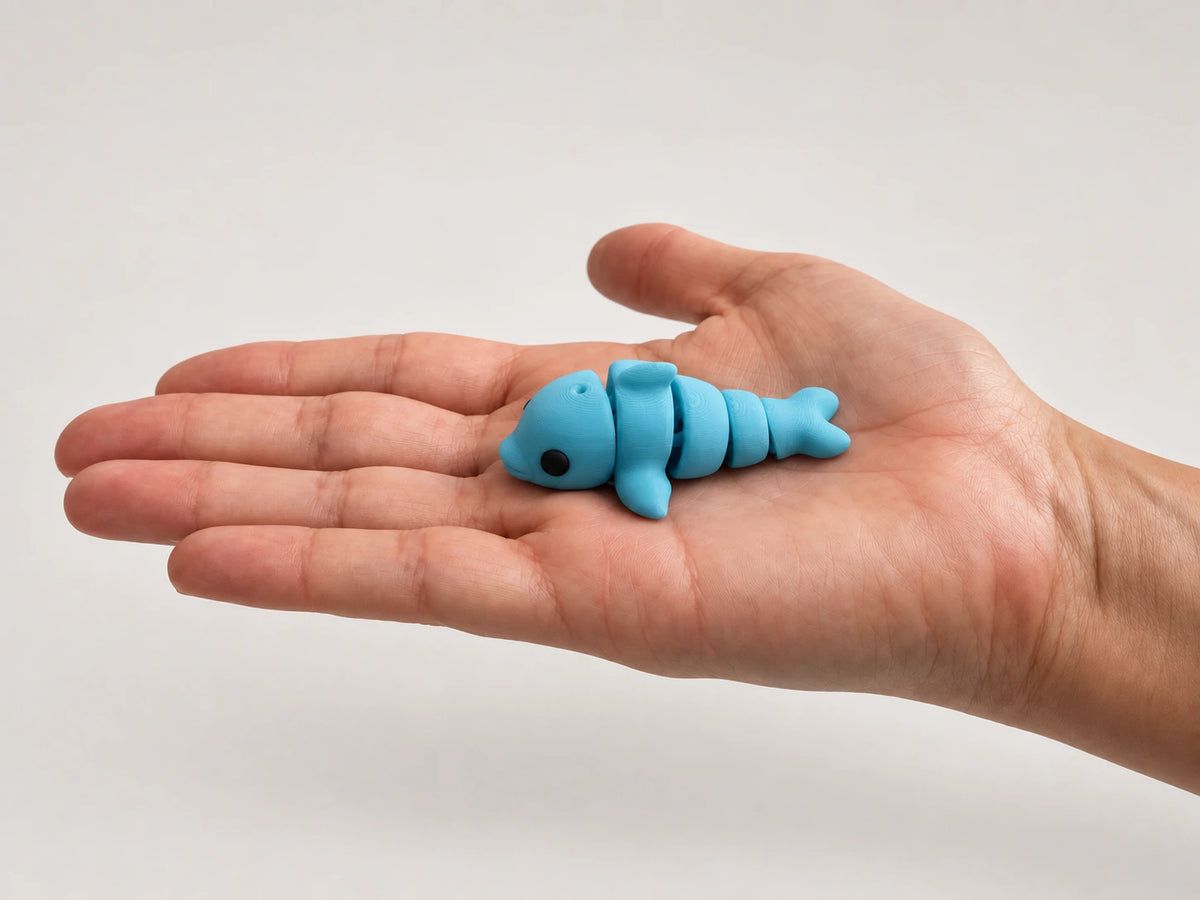 Dennis (Dolphin) articulated fidget resting in an open hand.