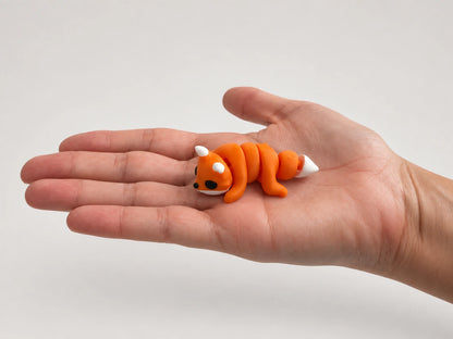 Frank (Fox) articulated fidget resting in an open hand.