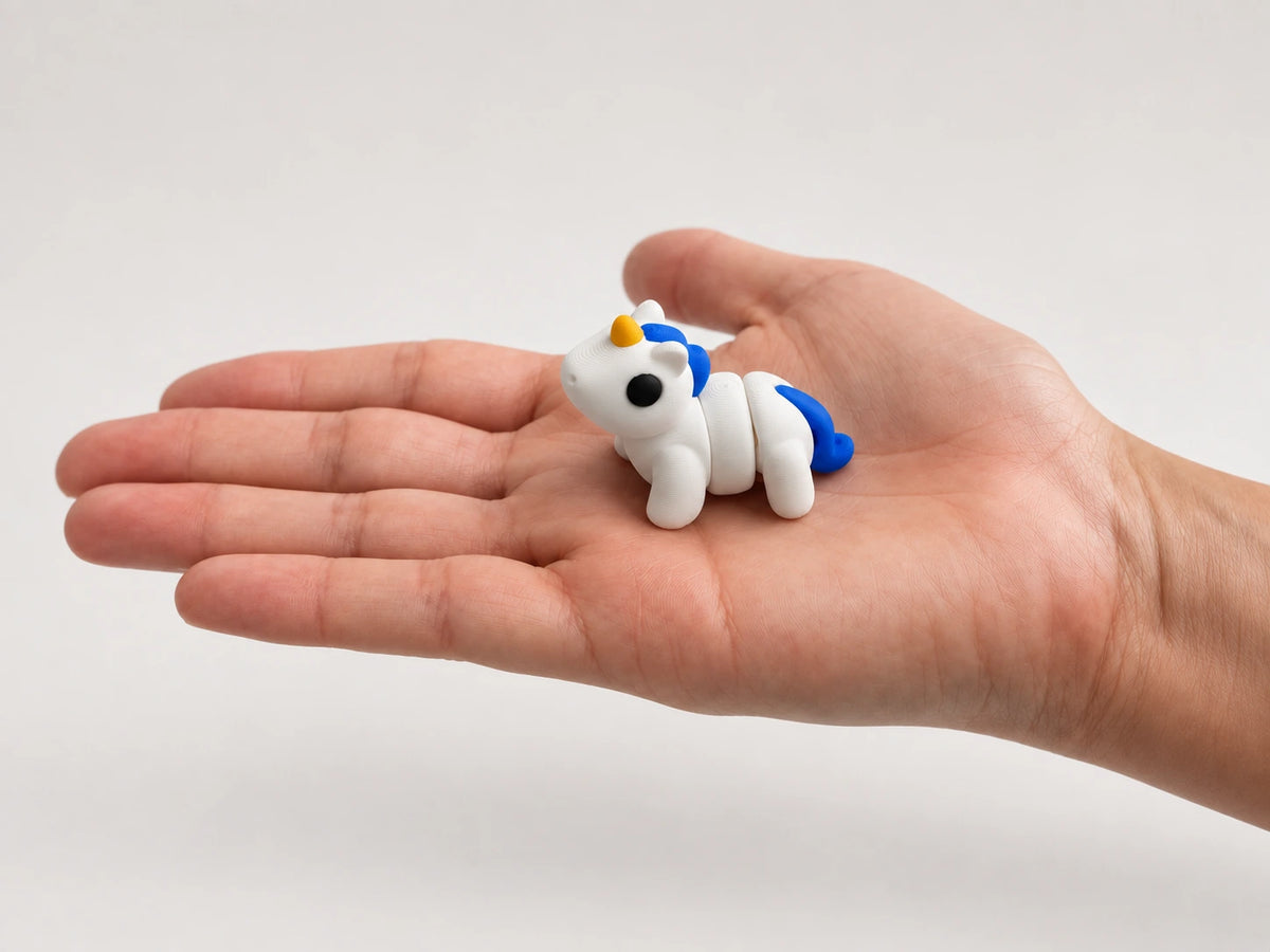 Luna (Unicorn) articulated fidget resting in an open hand.