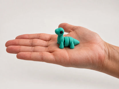 Nessie (Loch Ness Monster) articulated fidget resting in an open hand.