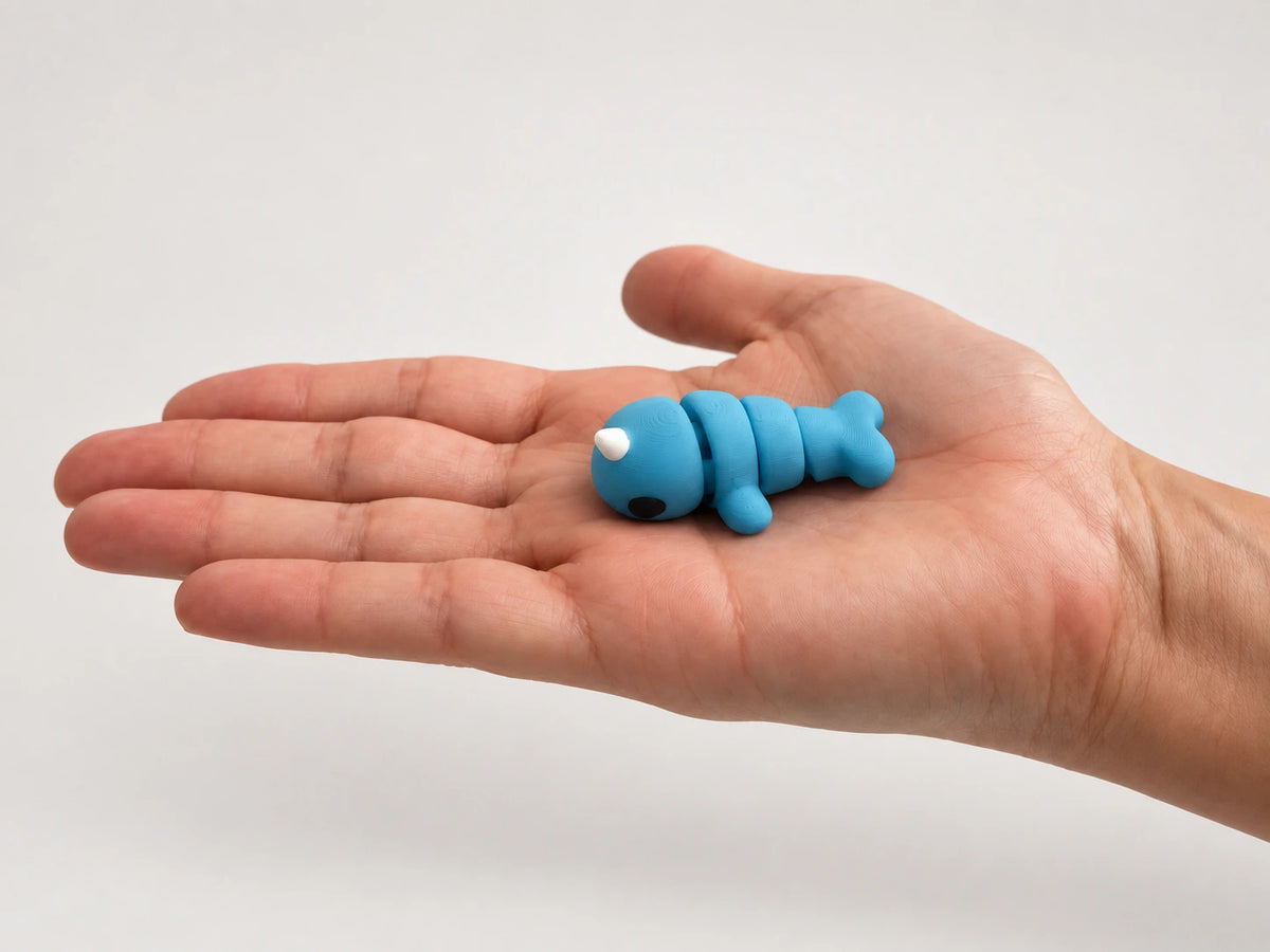 Nova (Narwhal) articulated fidget resting in an open hand.