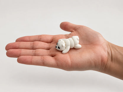 Paisley (Polar Bear) articulated fidget resting in an open hand.