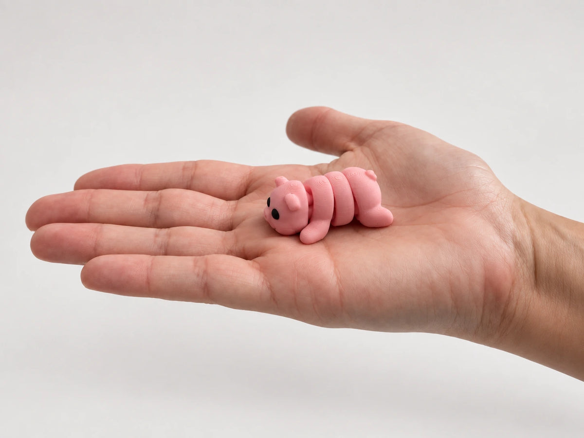 Penelope (Pig) articulated fidget resting in an open hand.