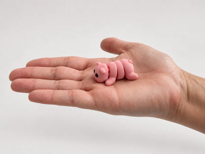 Penelope (Pig) articulated fidget resting in an open hand.
