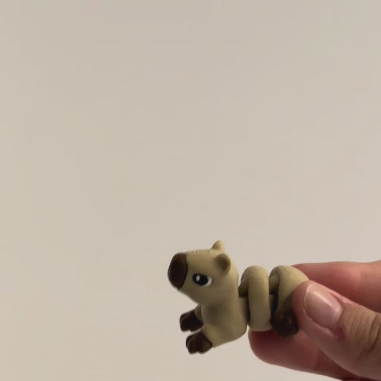 Capybara articulated fidget shown moving in a hand.
