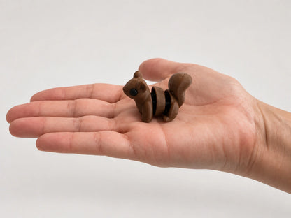 Squirrel Fidget articulated fidget resting in an open hand.