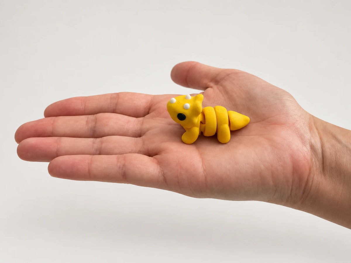 Tilly (Triceratops) articulated fidget resting in an open hand.