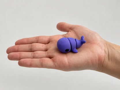 Whale Fidget articulated fidget resting in an open hand.